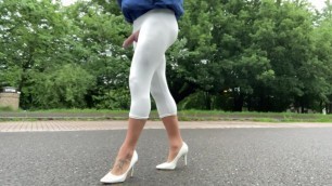White cropped leggings walking a public road.